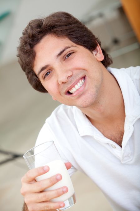 Happy man drinking a glass of milk