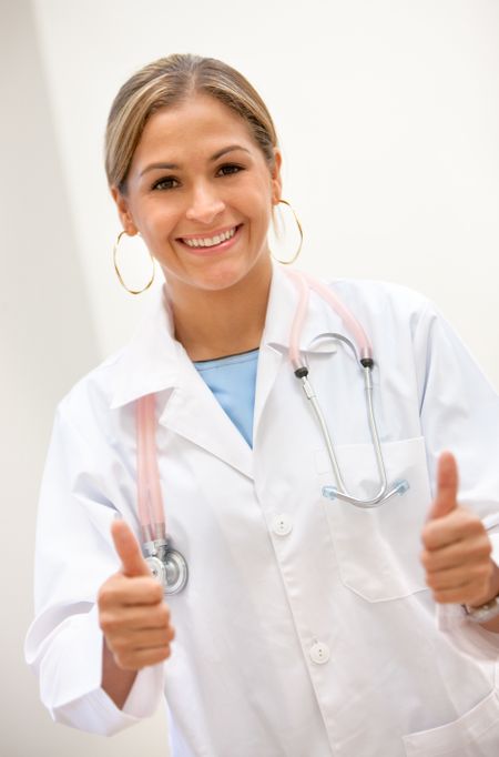 Female doctor smiling with thumbs up at the hospital