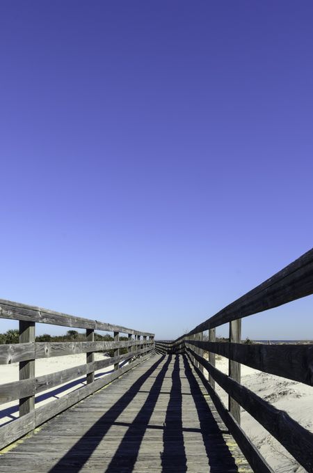 This way to the beach: Boardwalk perspective with morning shadows above dunes along the Atlantic coast in northeastern Florida, for themes of travel and tourism, exploration, conservation, environment