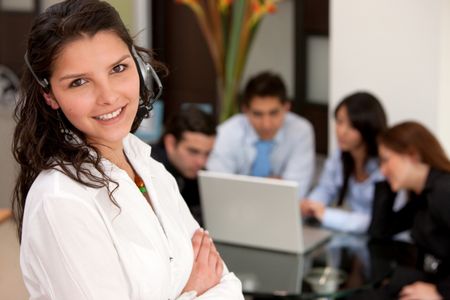 Business woman with headset and a group behing her