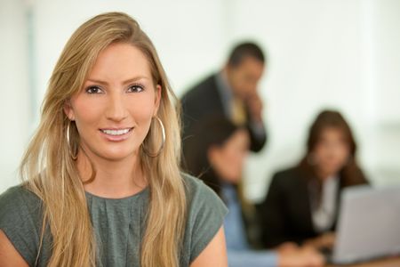 Business woman portrait with a team behind her