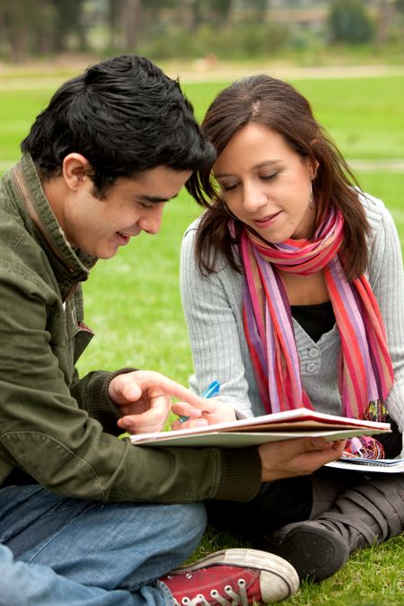 Beautiful couple studying outdoors smiling -education concepts