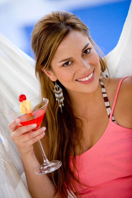 Beautiful woman holding a cocktail and smiling