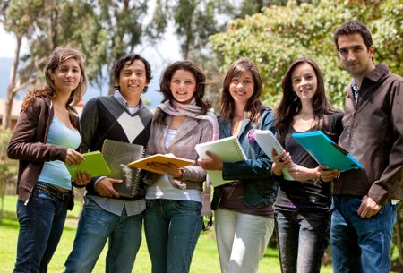Happy group of students outdoors holding notebooks