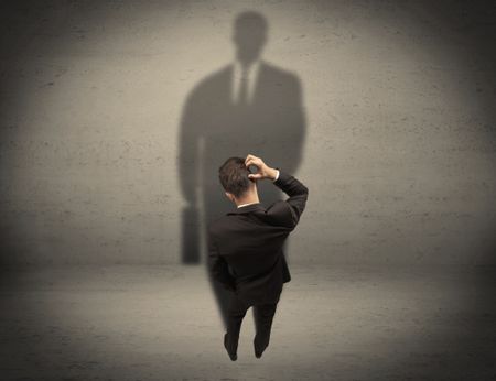 young-beginner-salesman-standing-front-wall-341846972 A young beginner salesman standing in front of a wall, facing his shadow as his boss or a successful businessman he lloks up to concept
