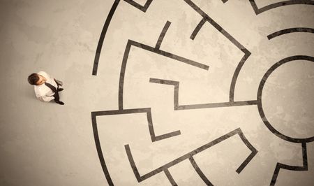 Lost business man looking for a way in circular labyrinth concept