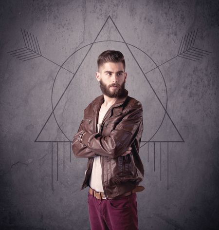 A young hipster male in modern clothes standing in front of an urban wall with modern sign illustration concept