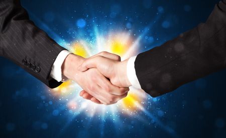 Two business men shaking hands with a successes agreement with explosion 