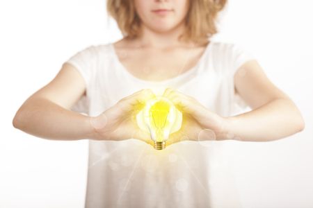 Hands creating a form with yellow light bulb in the center