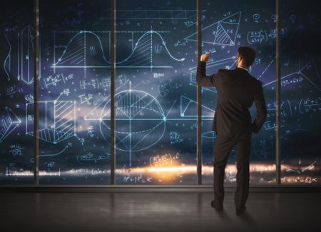 Businessman drawing business graphs on glass wall
