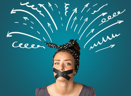 Young woman with taped mouth and white drawn lines and arrows around her head