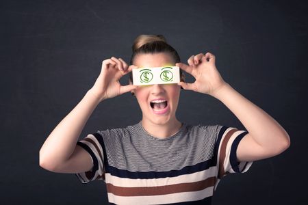 Young girl holding paper with green dollar sign concept