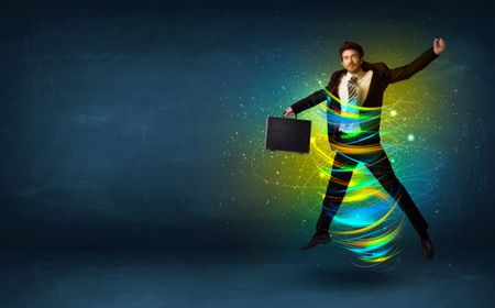 Excited business man jumping with energy colourful lines around him