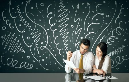 Business couple sitting at table with drawn curly lines and arrows on the background
