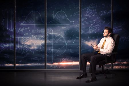 Businessman holding tablet in office room with graph charts on window concept
