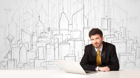 Businessman sitting at the white table with hand drawn buildings in the background