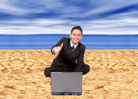 Business man with a computer online at the beach
