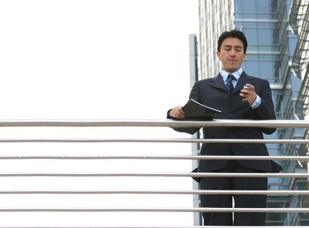 business man dialling on a mobile phone in a corporate environment