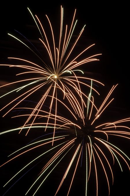 Two spidery bursts of fireworks, one with hot spot