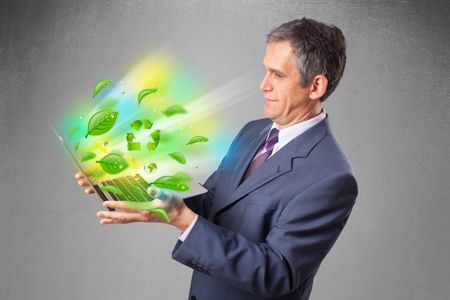 Handsome businessman holding laptop with recycle and environmental symbols