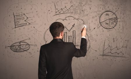 Businessman drawing a business project on a wall