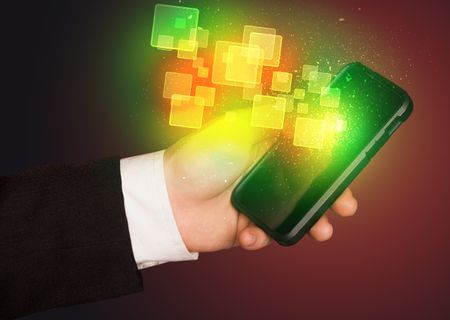 Hand holding smart phone with abstract glowing squares concept