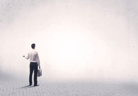 Serious business man standing on grey brick floor and thinging about decisions concept