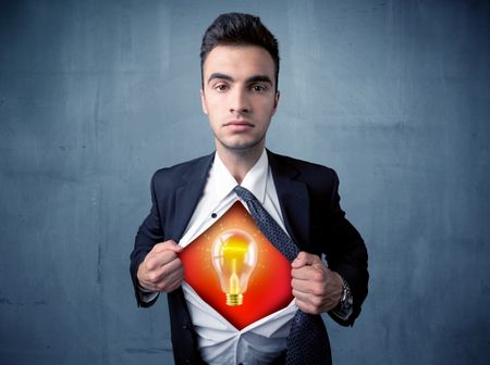 Businessman ripping off shirt and idea light bulb appears on his chest concept on backround