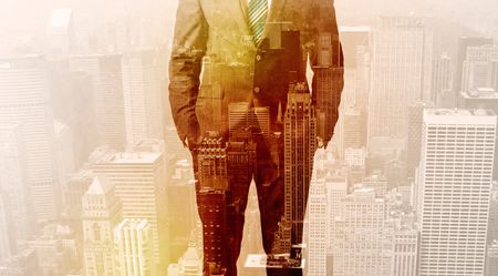 Business man looking at warm overlay city background