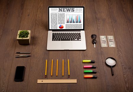 Computer laptop on wooden desk with office accessories 