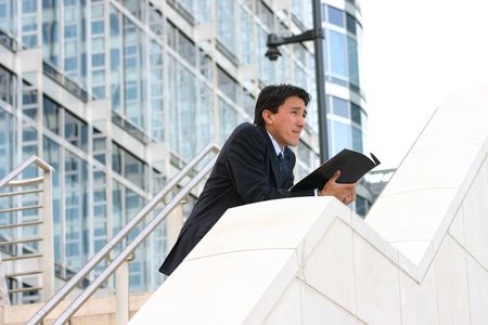 business man looking at the horizon with a magazine on his hands