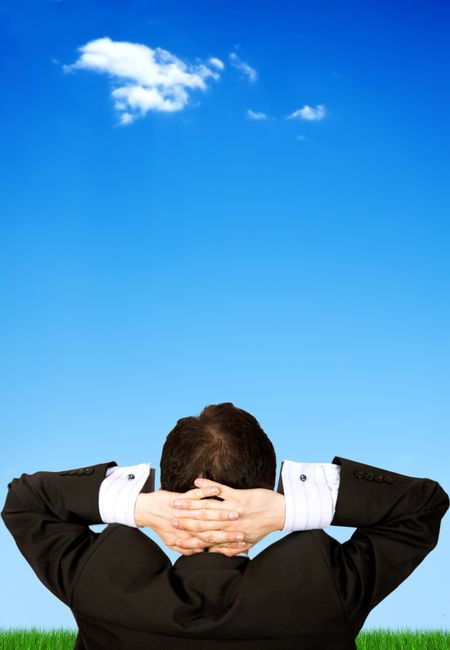 business man relaxing outdoors in front of a beautiful blue sky