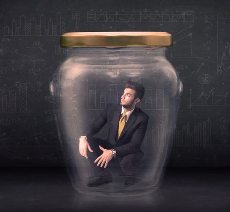 Business man closed into a glass jar concept on background