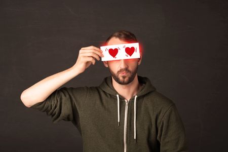 Cut man holding paper with read heart drawing concept