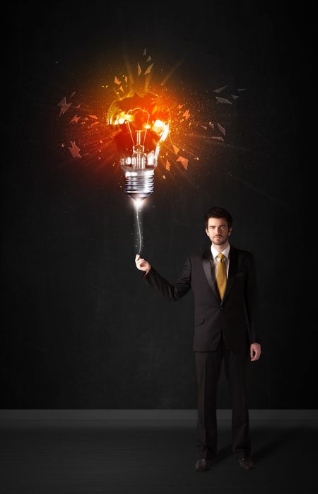 Businessman with an explosion bulb on black background