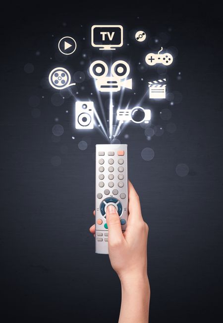 Hand holding a remote control, media icons coming out of it
