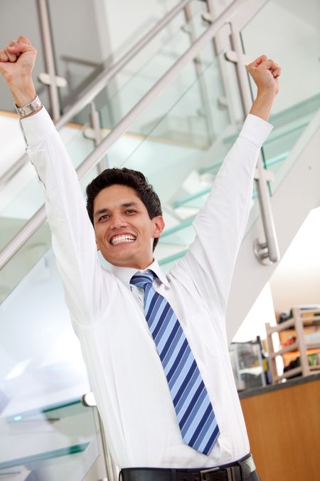 Successful business man with arms up in an office