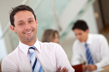 business man in an office with a group behind