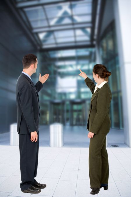 Business couple pointing at a modern building