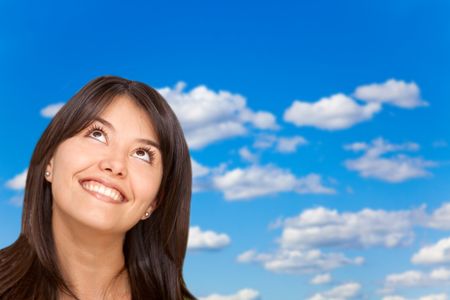 Pensive woman with a beautiful blue sky as background
