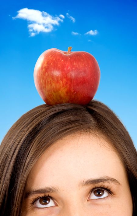 girl with apple on her head over a beautiful blue sky in the background