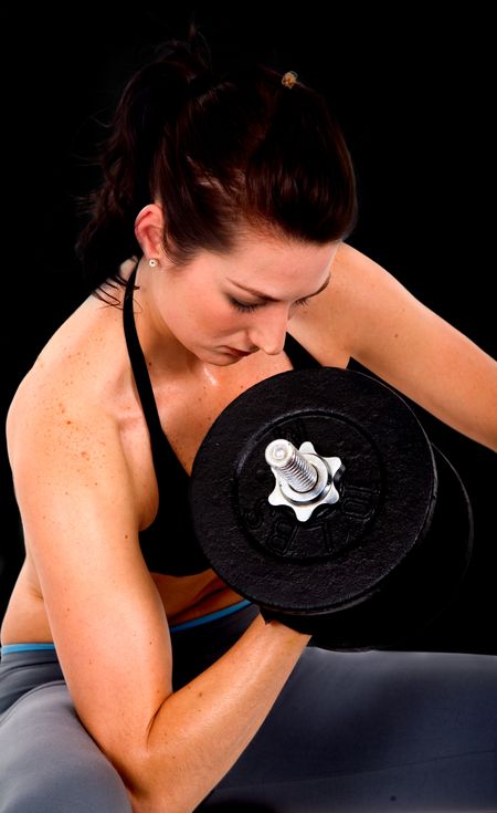 girl exercising with free weights over a black background
