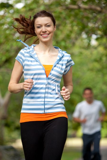 Athletic woman running at the park smiling