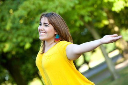 woman outdoors with her arms opened feeling the wind