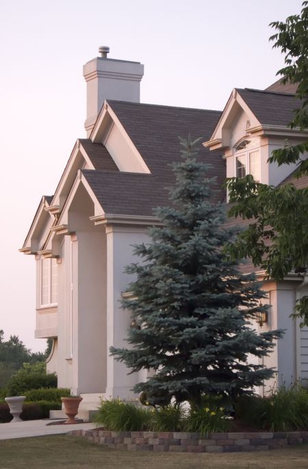 Suburban house with multiple peaks in shingled roof