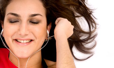 girl listening to music on the floor with her eyes closed - isolated over a white background