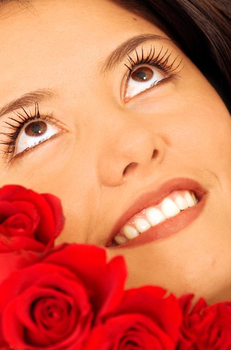 beauty portrait of a girl with red roses with a pensive and pleasant face