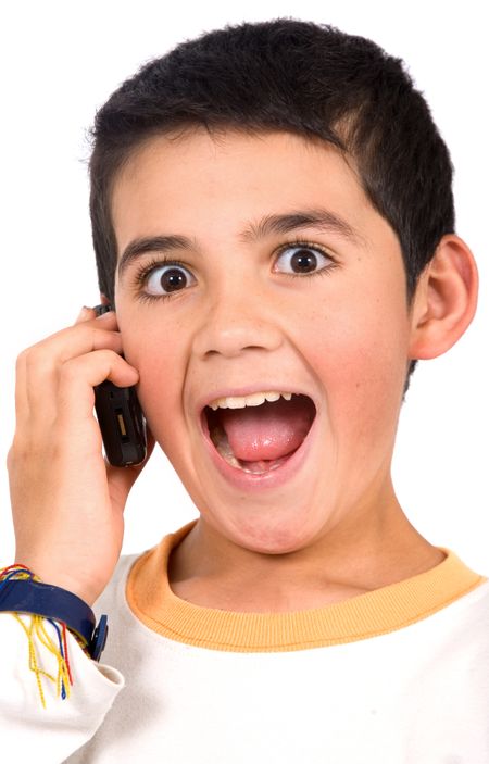 Kid on the phone looking surprised to hear the good news - isolated over a white background