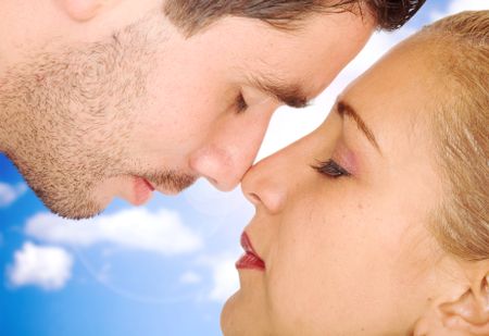 couple in love face to face - over a blue sky