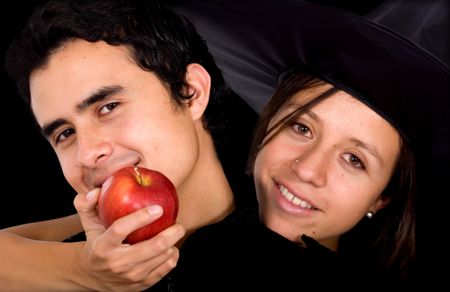 girl in a couple holding the apple of temptation for the man - isolated over a black background